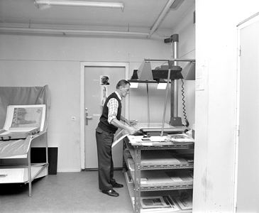 883279 Afbeelding van Marten van der Velde, medewerker van de gemeentelijke fotodienst in het gebouw van het ...